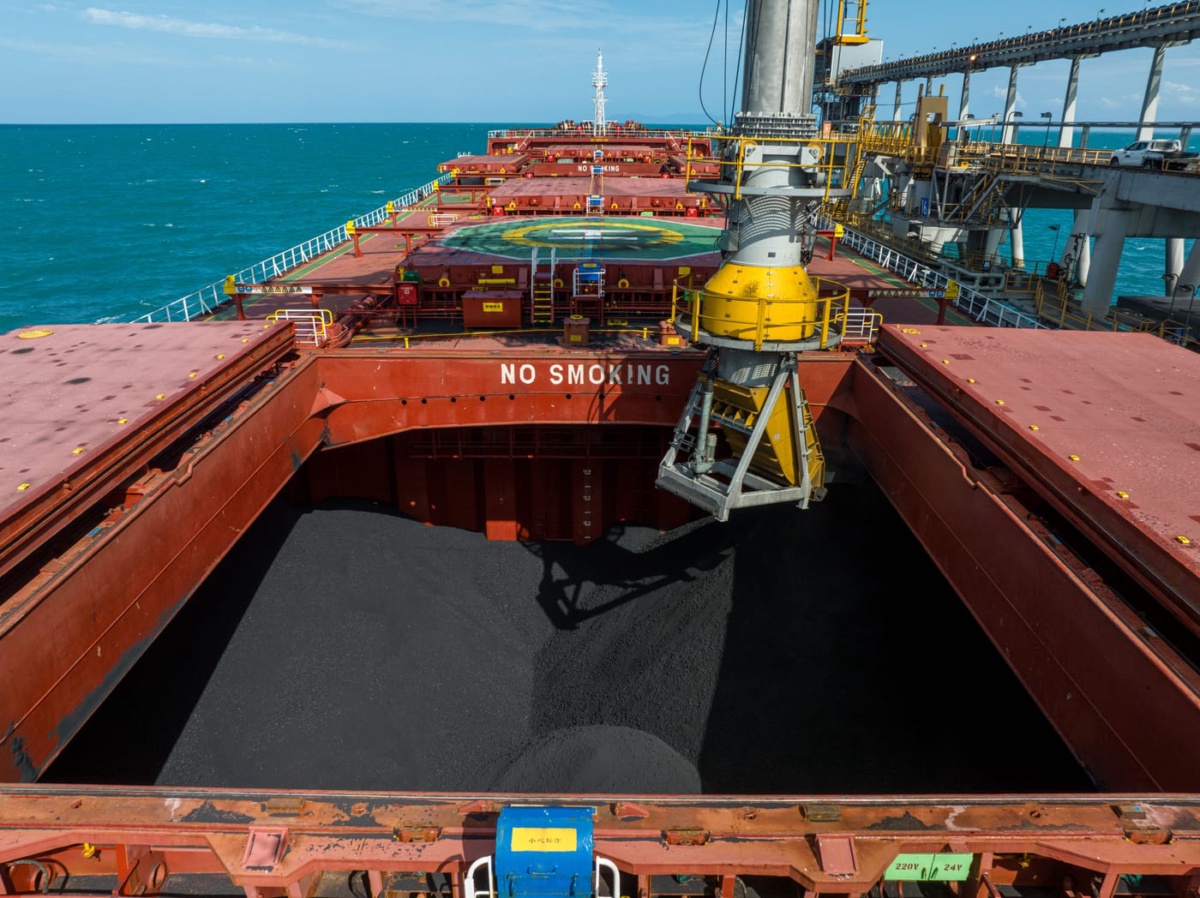 Coal being loaded into the hold of a bulk carrier at berth